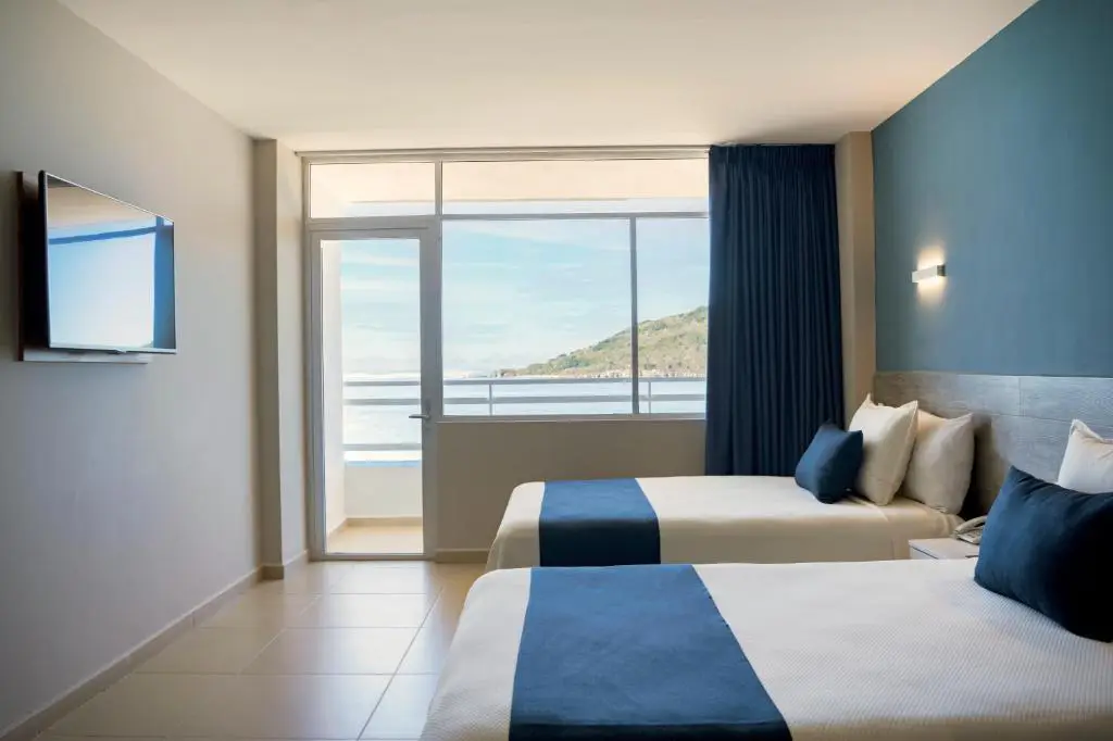 Habitación doble con camas separadas, balcón y vista al océano en hotel Star Palace Mazatlán, perfecta para disfrutar una estancia frente al mar con Royal Beach Paradise.