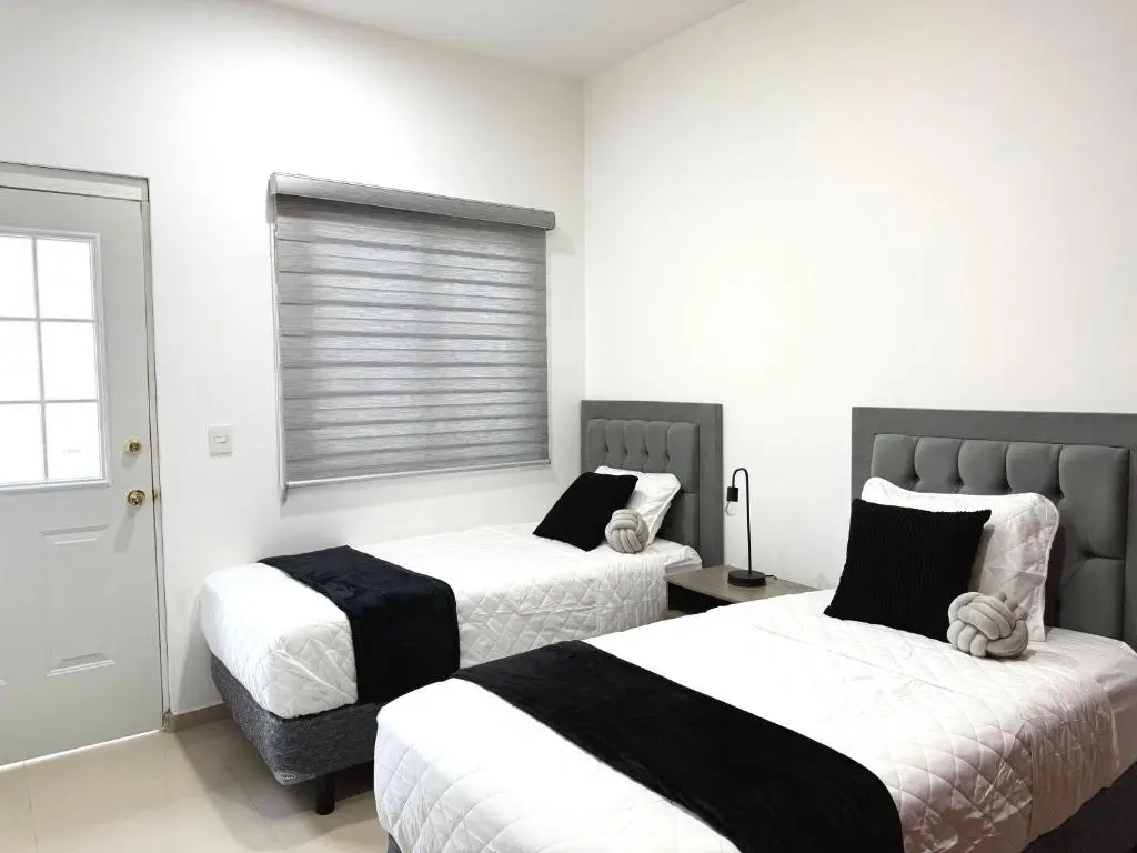 Habitación doble moderna con camas separadas y diseño minimalista en hotel de Mazatlán, ideal para disfrutar confort y tranquilidad con Royal Beach Paradise.